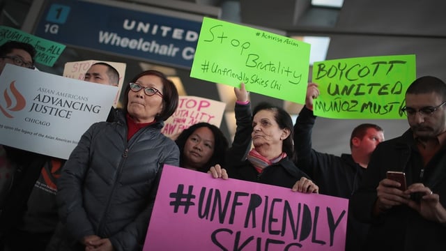 Angry protestors hold signs condemning the actions of United