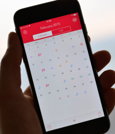 An iPhone displays a calendar that is used to schedule shifts on the Shift app.
